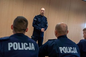 Policjant stoi na przeciwko uczestnikom kursu