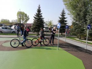 policjantka z dziećmi na rowerach w miasteczku rowerowym