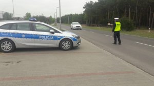 Policjant przy pomocy tarczy tzw. lizaka daje kierocy sygnał do zatrzymania