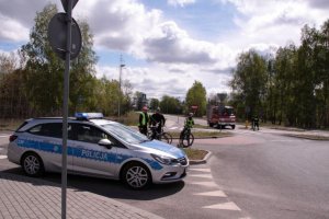 Policyjny radiowóz zabezpiecza drogę przejazdu rowerzystom uczestniczącym w rajdzie.