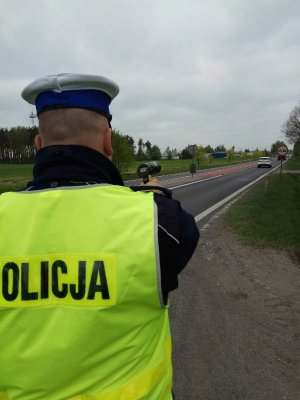 Policjant dokonujący ręcznego pomiaru prędkości.