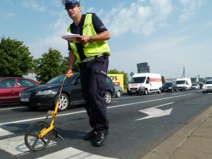 Przykładowe zdjęcie z miejsca wypadku. Policjant z WRD z przyrządem do mierzenia odległości.