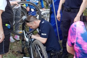 policjant graweruje znaki na ramie roweru