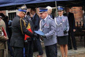 Toruńskie Obchody Święta Policji . Msza Święta z udziałem biskupa toruńskiego Jego Ekscelencji Wiesława Śmigla. Uczestniczący policjanci i kompania honorowa oraz orkiestra, przemarsz na Rynek Staromiejski. Komendant Wojewódzki  insp. Paweł Spychała oraz Komendant Miejski Policji w Toruniu insp. Maciej Lewandowski wręczający nominacje na wyższe stopnie oraz nagrody Prezydenta Miasta Torunia Michała Zaleskiego oraz Starosty Toruńskiego Marka Olszewskiego.Komendant Miejski w Toruniu wręczył pamiątkowe tablice na  jubileusz 100 lecia  powołania Policji Państwowej, którą powołano 24 lipca 1919 roku.