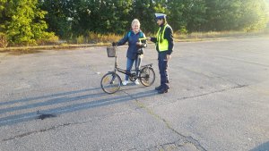 policjantka wręcza rowerzystce odblask