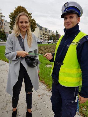 policjant wręcza odblask kobiecie