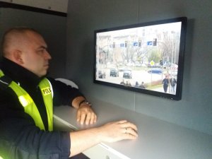 policjant przed ekranem monitoringu