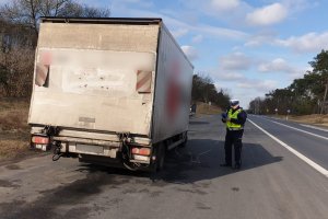 kontrola drogowa pojazdu dostawczego z użyciem analiztora spalin. Na zdjęciu umundurowany funkcjonariusz i samochód