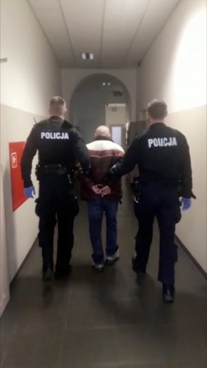 sprawca prowadzony przez policjantów