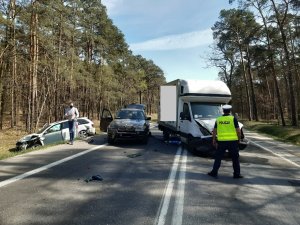 Policjanci obsługujący kolizję w Pędzewie oraz auta uczestniczące w zdarzeniu.