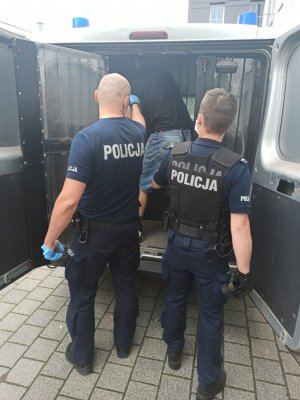 policjanci prowadzą zatrzymanego