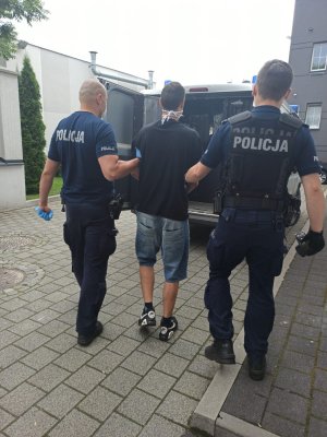 policjanci prowadzą zatrzymanego