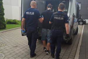 policjanci prowadzą zatrzymanego