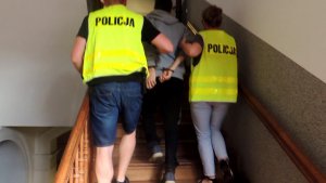 Policjanci z Chełmży w prowadzający podejrzanego po schodach komisariatu