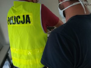 policjant wykonujący daktyloskopię zatrzymanemu sprawcy posiadania znacznej ilości narkotyków