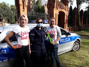 Policjantka i dwie uczestniczki festyny przy radiowozie