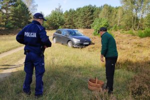 policjant legitymuje grzybiarza z koszykiem