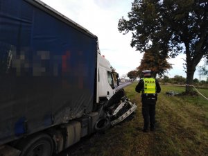 Zdjęcia ze śmiertelnego  wypadku w Ostaszewie pod Toruniem. NA zdjęciach pojazdy i funkcjonariusze  służby takich  jak policja straż pożarna, inspekcja transportu drogowego, holownik. Policjant podczas oględzin przy pojazdach. Osobowy pojazd pod kołami ciężarówki.