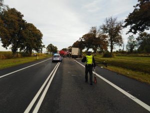 Zdjęcia ze śmiertelnego  wypadku w Ostaszewie pod Toruniem. Na zdjęciach pojazdy i funkcjonariusze  służb takich  jak policja straż pożarna, inspekcja transportu drogowego, holownik. Policjant na pierwszym planie mierzący za pomocą miary drogę jazdy.