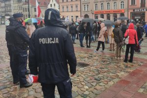 na pierwszym planie umundurowani policjanci, w tle ludzie