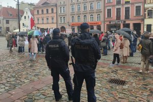 na pierwszym planie umundurowani policjanci, w tle ludzie