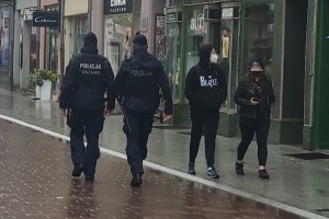 ulica, dwójka policjantów mija parę w maseczkach