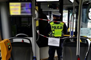 wnętrze autobusu, policjant stoi przy przedziale kierowcy