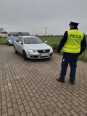 Policjanci Wydziału Ruchu Drogowego podczas przeprowadzania kontroli oświetlenia pojazdów-  Akcja  Twoje światła - Twoje bezpieczeństwo&quot;