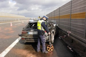 Zdjęcie z miejsca wypadku na autostradzie A1. Na zdjęciu widoczne zniszczone uderzeniem auto i pracujący na miejscu policjanci, którzy zabezpieczają ślady.