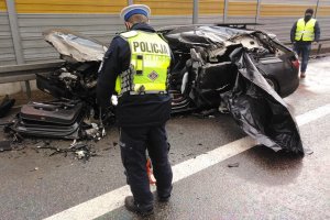 Zdjęcie z miejsca wypadku na autostradzie A1. Na zdjęciu widoczne zniszczone uderzeniem auto i pracujący na miejscu policjanci, którzy zabezpieczają ślady.