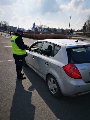 Policjant Wydziału Ruchu Drogowego podczas kontroli pojazdu.