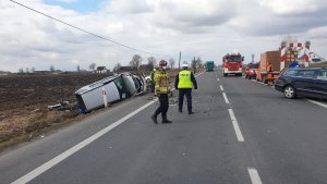 Zdjęcia z wypadku na DK 91 w Ostaszewie. Na jezdni  widoczne fragmenty pojazdu, w rowie pojazd marki mercedes koloru srebrnego. Widać również strażaków i policjantów pracujących na miejscu.