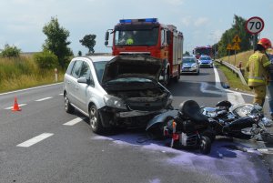 Zdjęcie z miejsca wypadku w miejscowości Wola gmina Czernikowo. Na miejscu widoczne pracujące służby ratunkowe i policja, oraz pojazdy uczestniczące w zdarzeniu czyli opel zafira i przewrócony przy nim motocykl harley davidson.