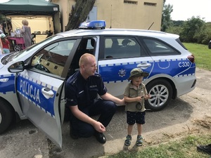 policjant pokazuje dziecku radiowóz