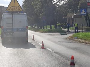 Zdjęcia z miejsca kolizji na ul. Kościuszki w Toruniu. Policjanci wykonujący czynności, radiowóz policji z napisem wypadek oraz leżąca na jezdni hulajnoga.