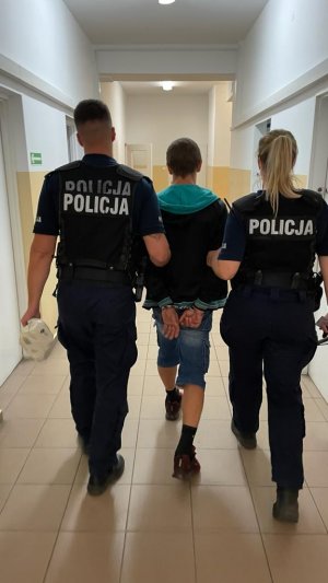 zdjęcie  zabezpieczonych narkotyków. zdjęcie jak policjanci prowadza podejrzanego korytarzem komisariatu.