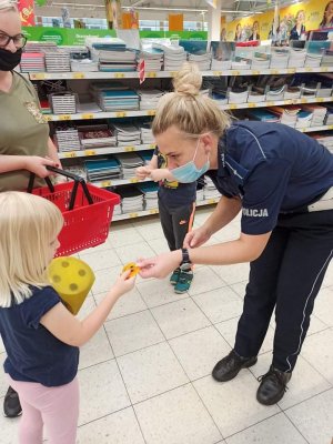 Zdjęcia z akcji  Bezpieczny powrót do szkoły. Policjanci podczas rozmów z dziećmi i dorosłymi oraz gry na temat bezpieczeństwa w ruchu drogowym.