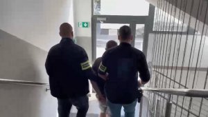 zdjęcia podejrzanego 20 latka prowadzonego korytarzem Komisariatu Policji Toruń Rubinkowo  przez policjantów służb Kryminalnych.