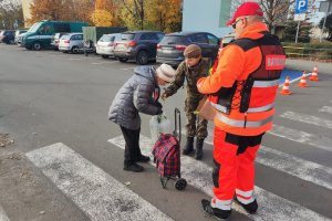 ratownik medyczny i żołnierka wręczają odblaski