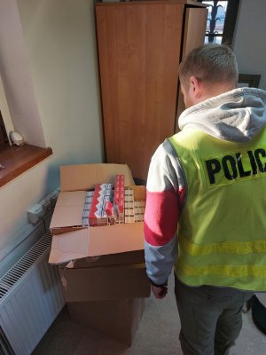 kartony z papierosami i policjant w kamizelce odblaskowej