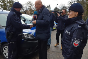 Mężczyzna przekazuje kluczyki do pojazdu policjantowi