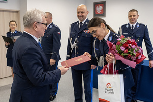 mężczyzna wręcza policjantce kwiaty