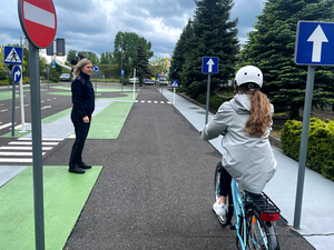 funkcjonariuszka przygląda się uczestnikom biorącym udział w egzaminie na kartę rowerową.