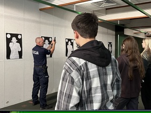 Policjant tłumaczy zasady bezpieczeństwa obowiązujące podczas użycia broni