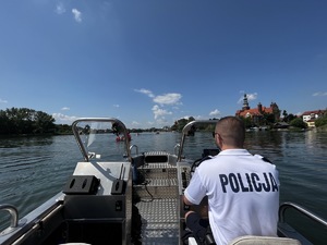 policjant za sterem łodzi policyjnej patroluje akwen