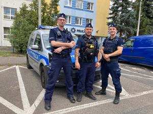 trzech policjantów stoi przed budynkiem jednostki Policji