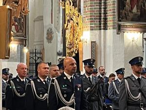 umundurowani policjanci stoją w kościele