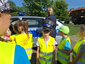 Dzieci przymierzają policyjną czapkę