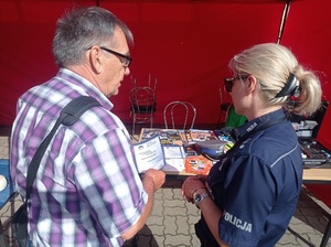 Policjantka przekazuje mężczyźnie ulotkę