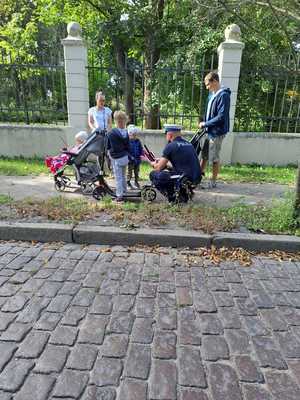 Policjant przekazuje elementy odblaskowe przechodniom